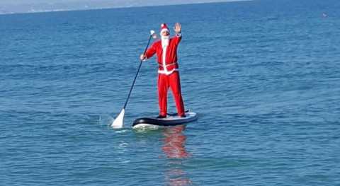 Bari, sulla spiaggia di Pane e Pomodoro pagaiata in sup vestiti da Babbo Natale